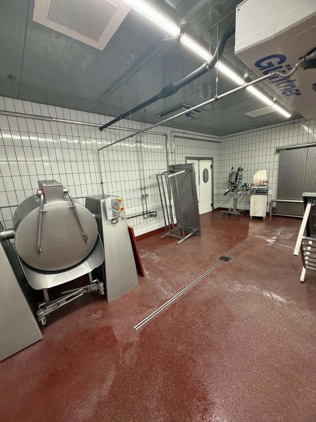 Produktionsraum mit rundem Edelstahlbehälter und Bodenrinne